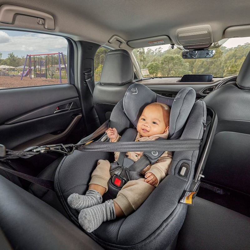 Baby in grey carseat with seatbelts