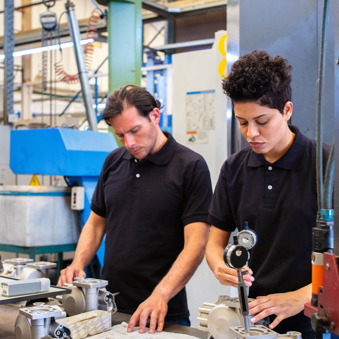 Man and woman at work bench holding tools