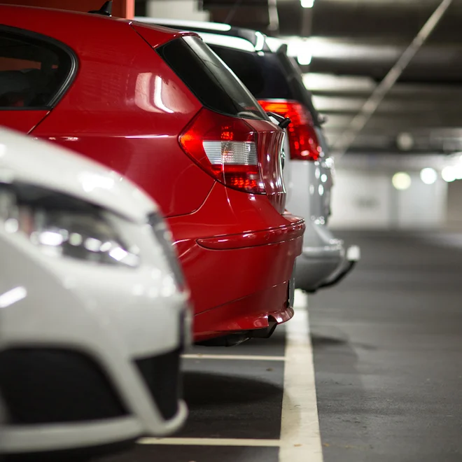 Red and white cars parked in carpark