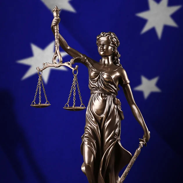 Statue of Lady Justice holding scales, set against an Australian flag. The image conveys themes of fairness and justice in an Australian context.