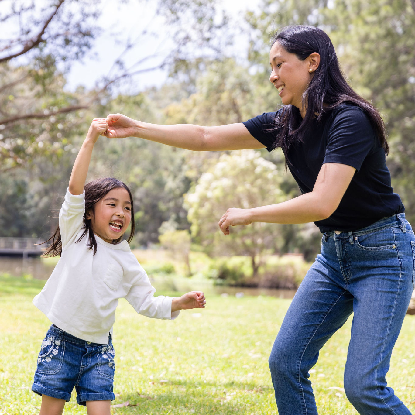 Mother and daughter dancing in backyard