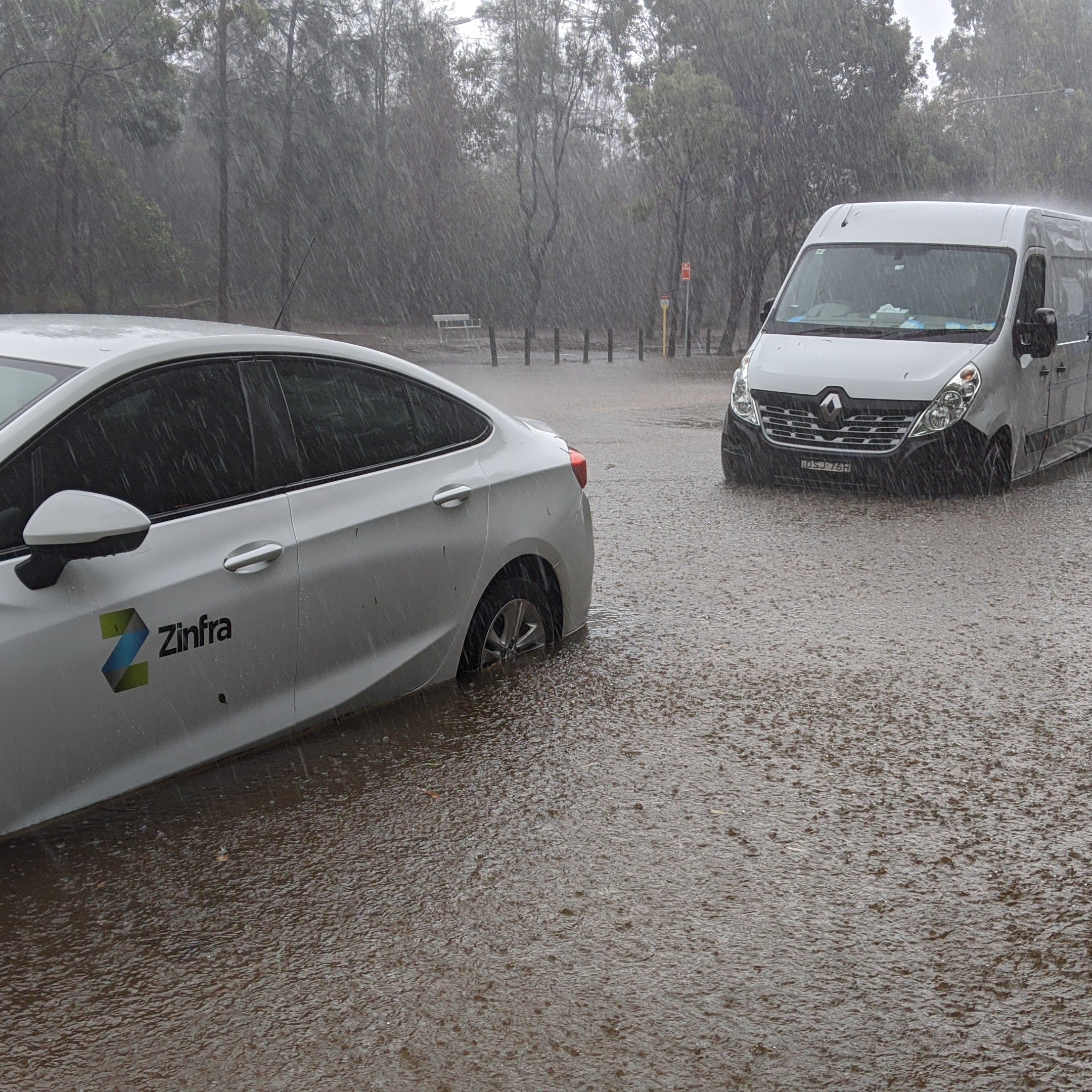 Two cars driving through flooded road